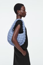 Placeholder for: Person holding blue quilted bag