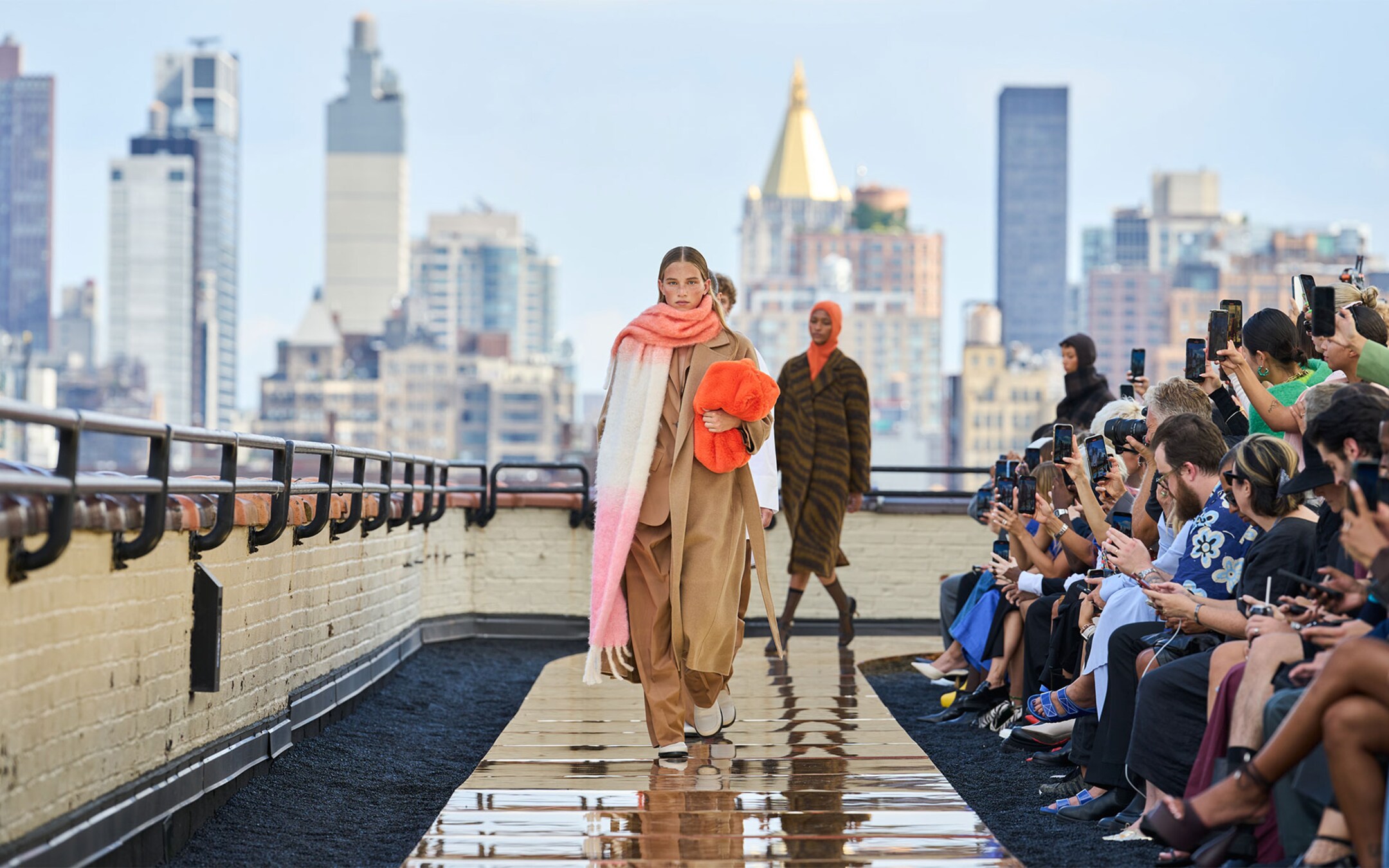 Person wearing oversized scarf, brown matching suit with beige maxi coat on