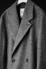 Placeholder for: Black and white image of wool herringbone coat on a coat hanger