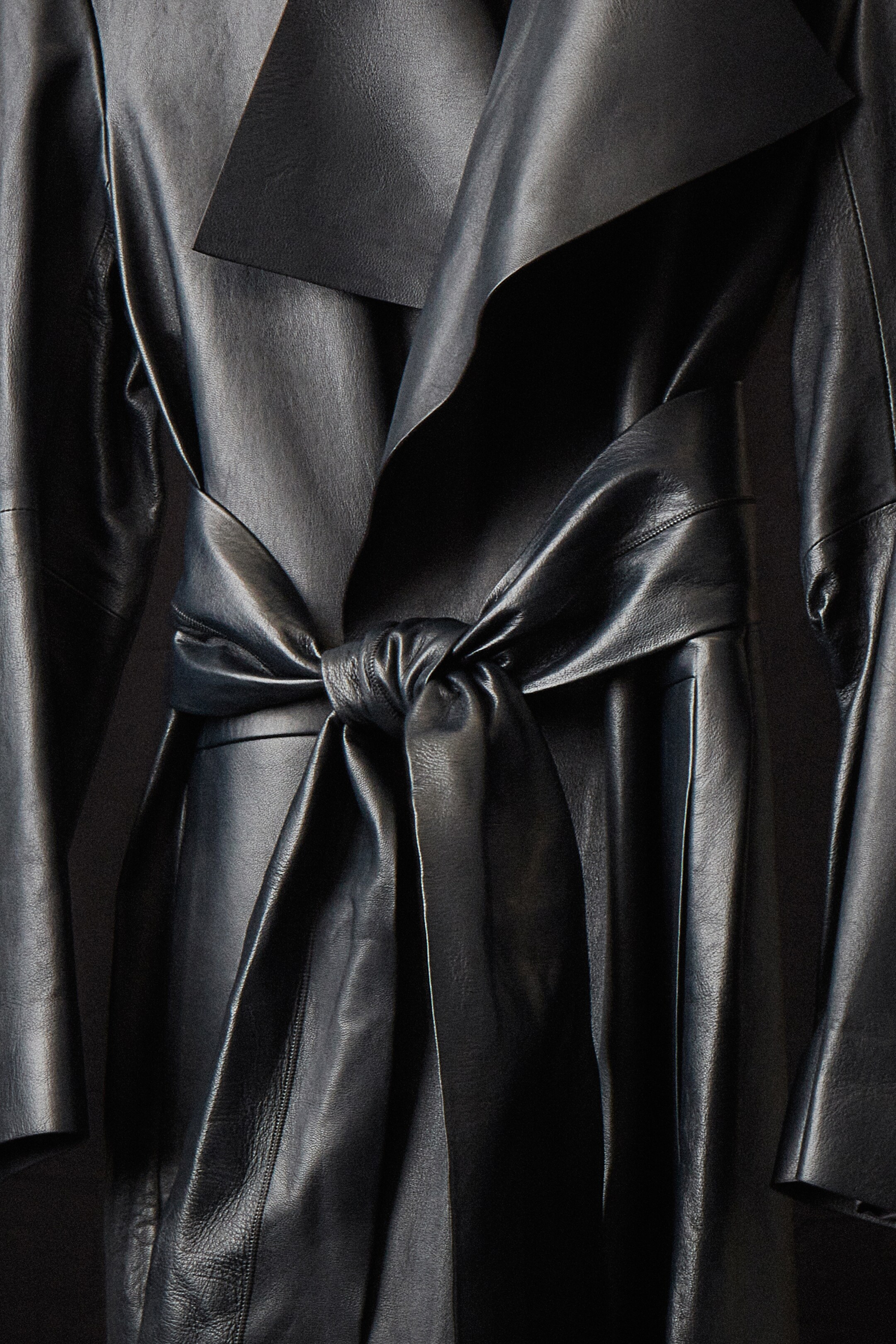 Close up image of COS leather trench coat