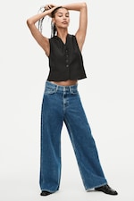 Placeholder for: Woman wearing black vest top and blue jeans