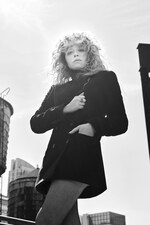 Placeholder for: Natasha Lyonne wearing black buttoned coat and fishnet tights