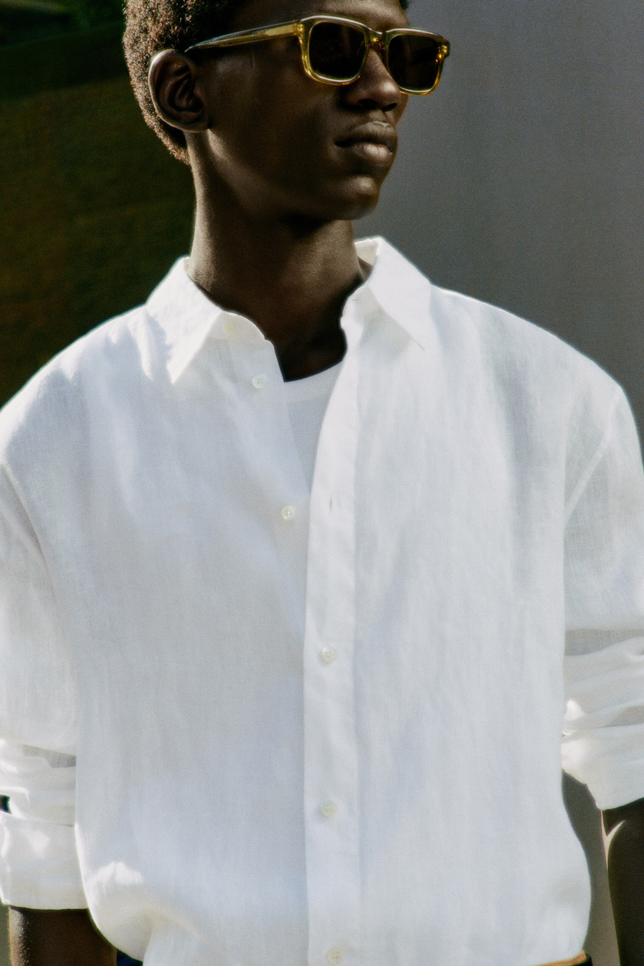 Man wearing sunglasses and white linen shirt