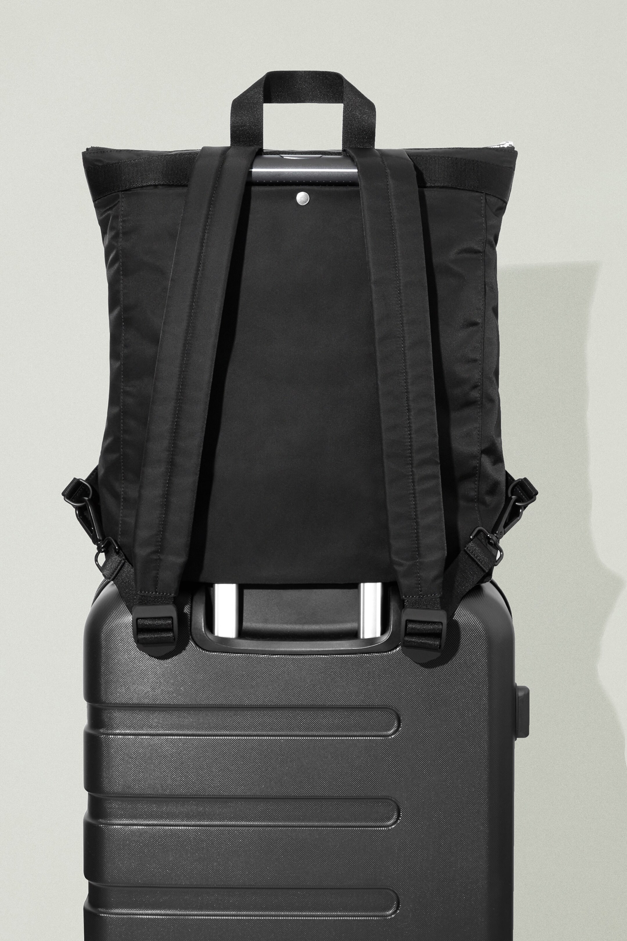 Black rucksack on black suitcase