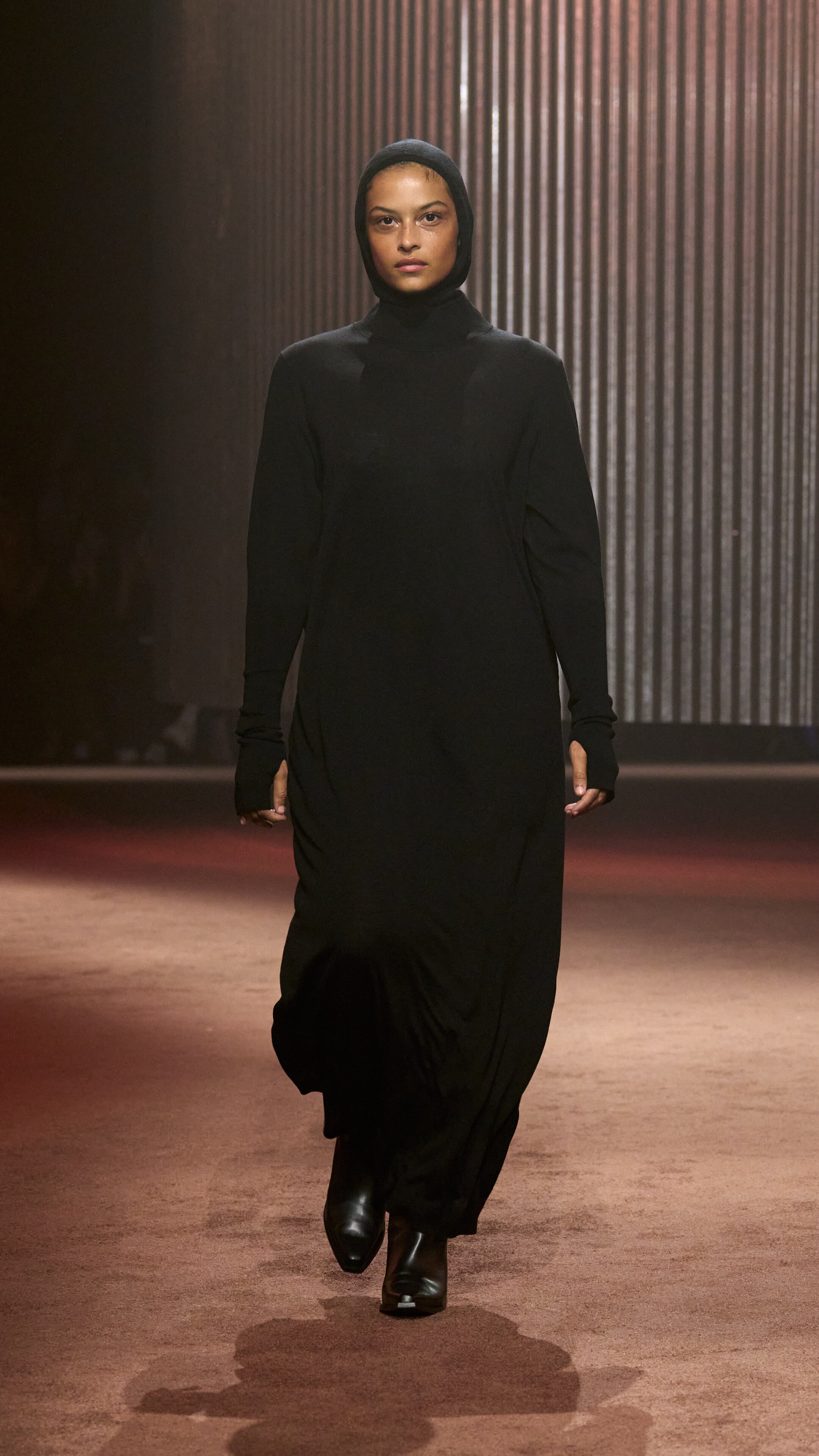 Woman wears black dress and black balaclava