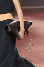 Placeholder for: Model wears black top, black skirt and holds black leather bag