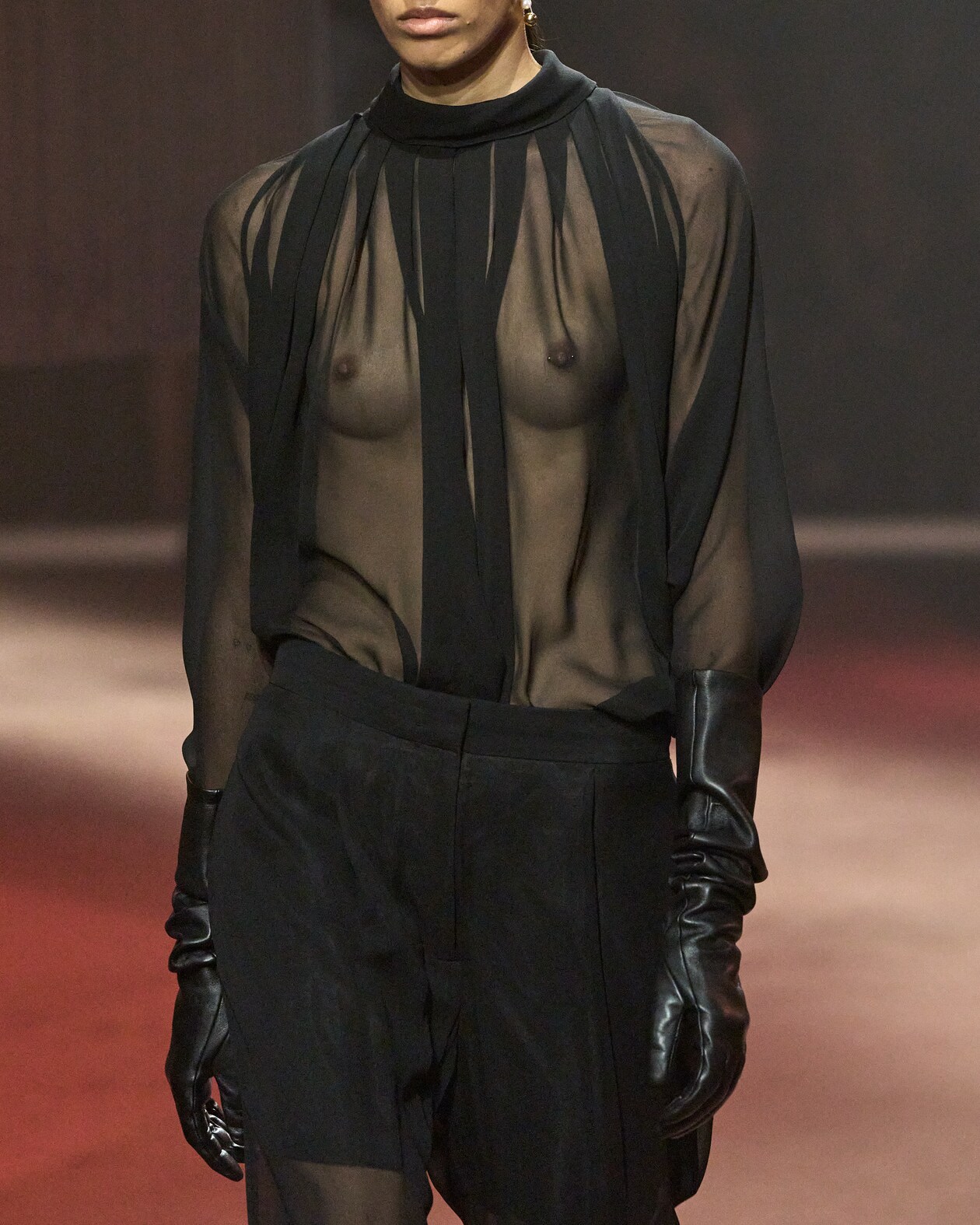 Model wears black sheer top, black shorts and black gloves