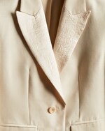 Placeholder for: close up of cream blazer with silk panels