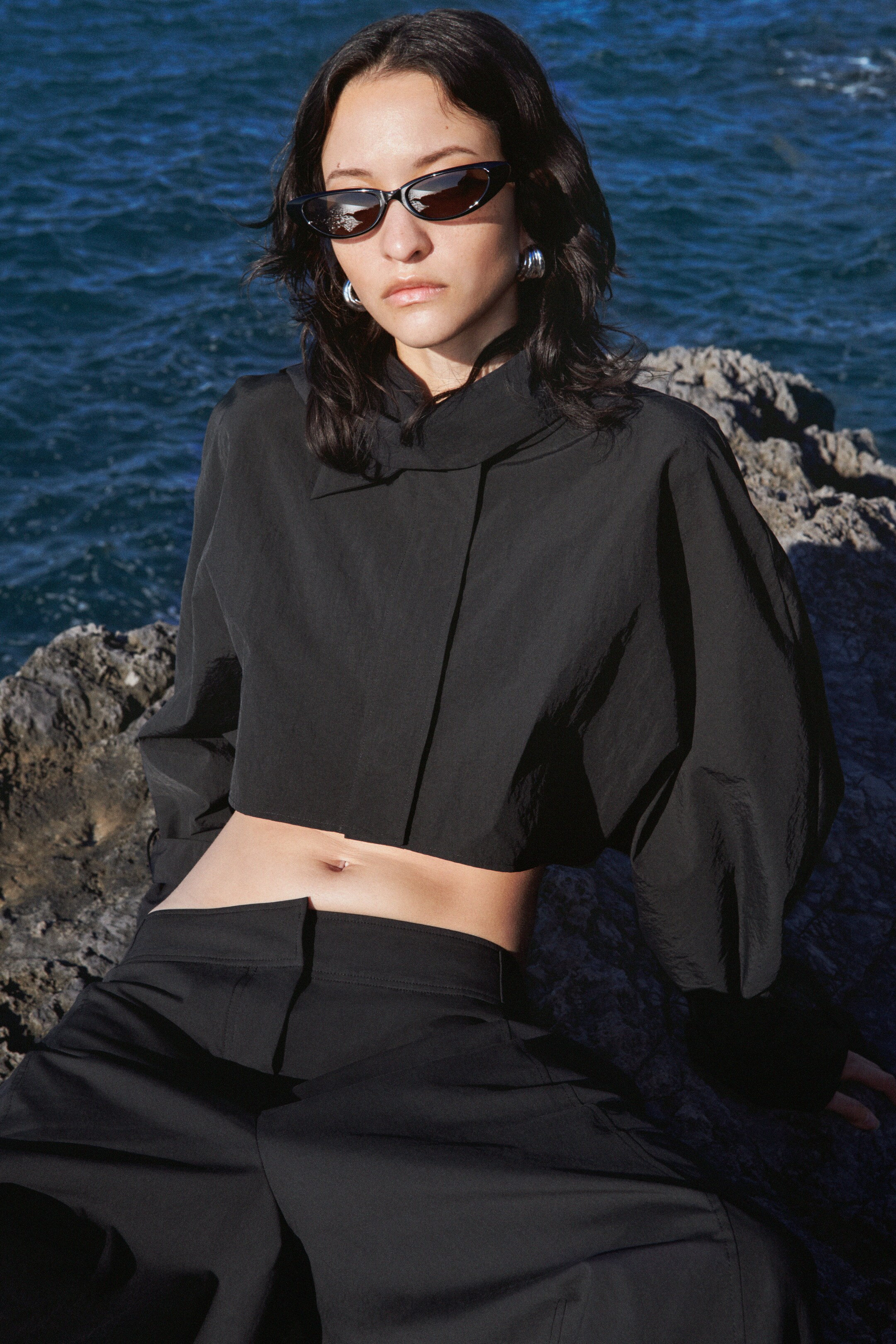 model wearing black top and sunglasses