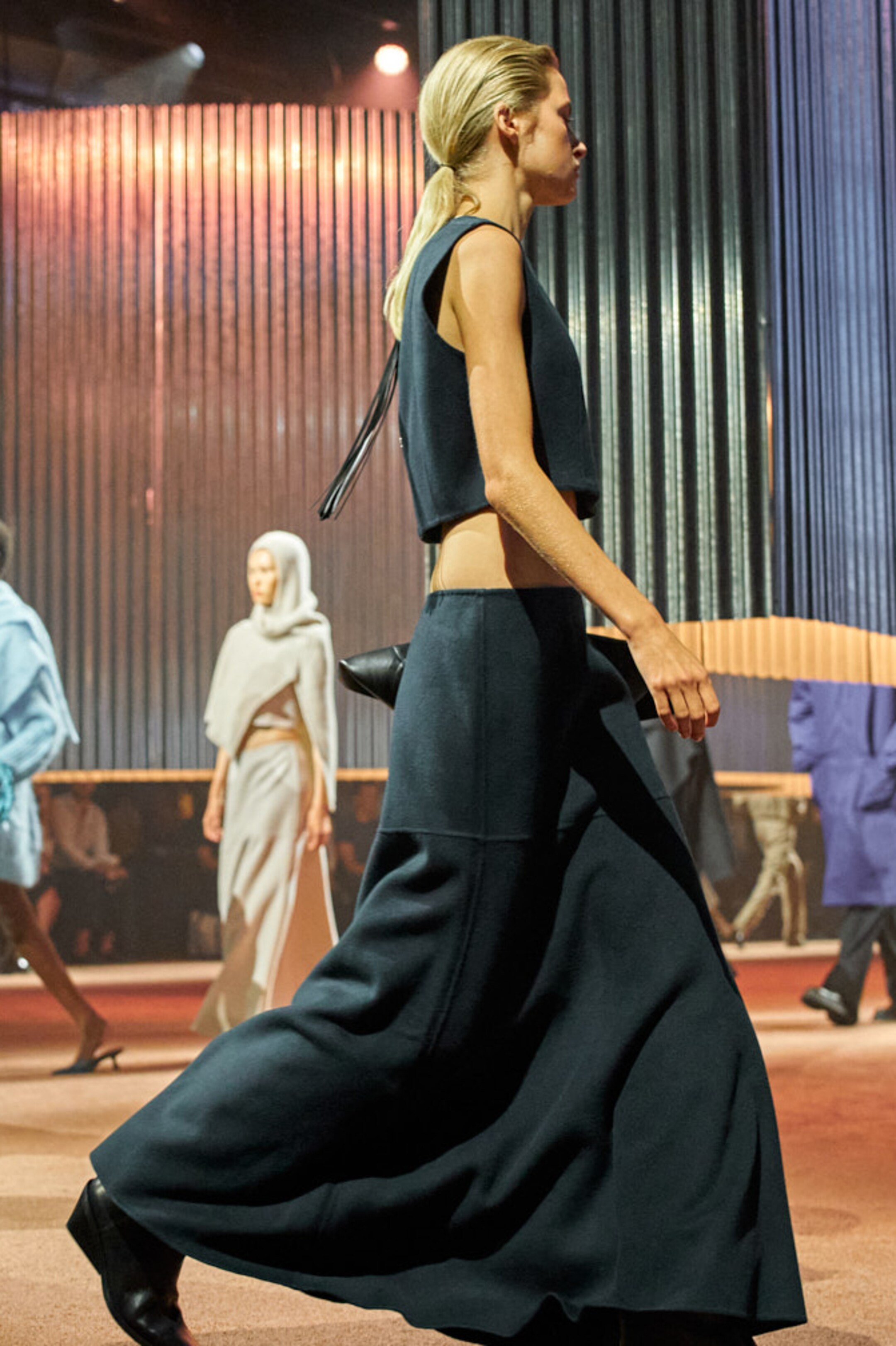 Person wearing black cropped vest and black maxi skirt