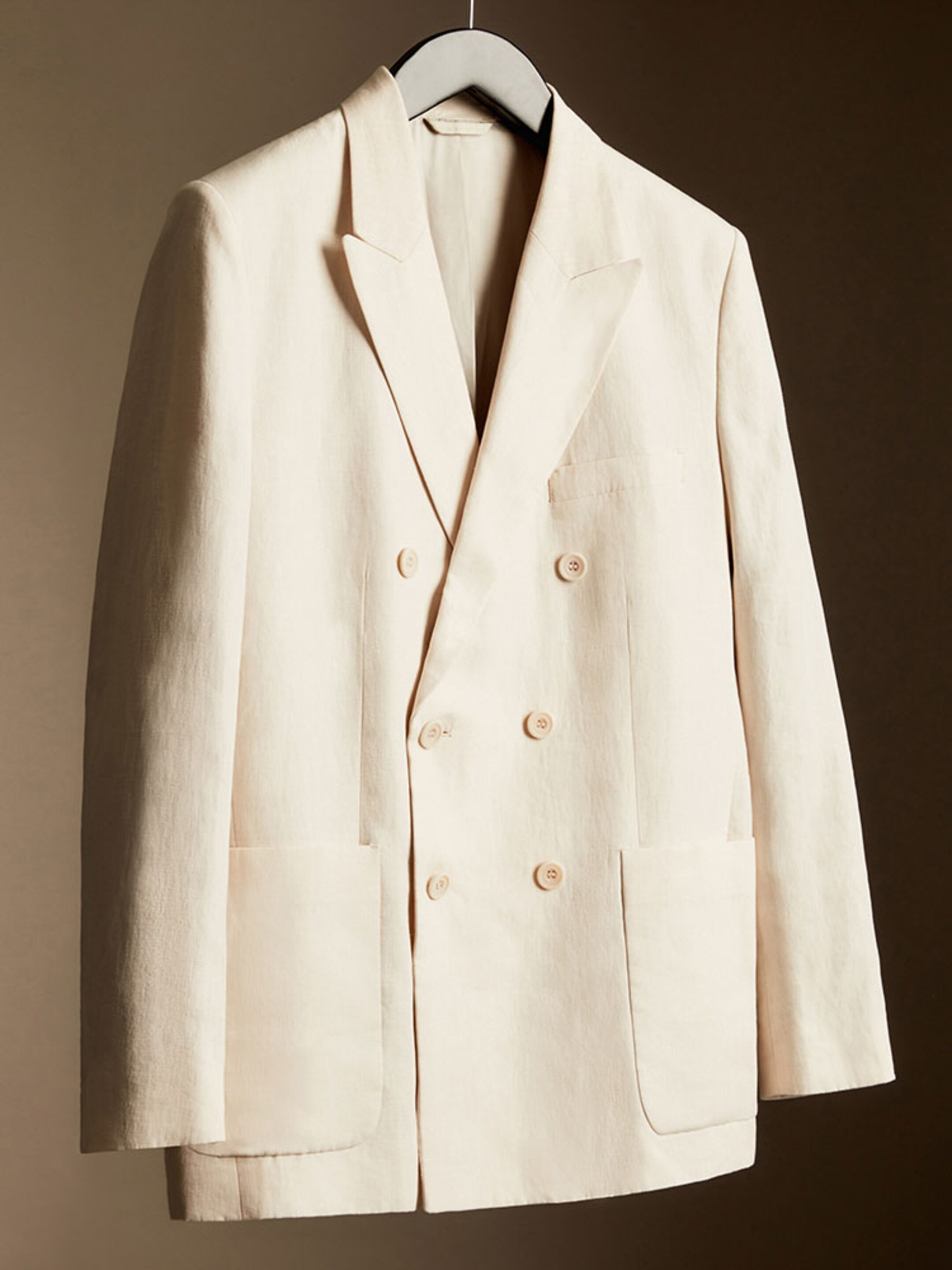 Cream double breasted blazer on coat hanger