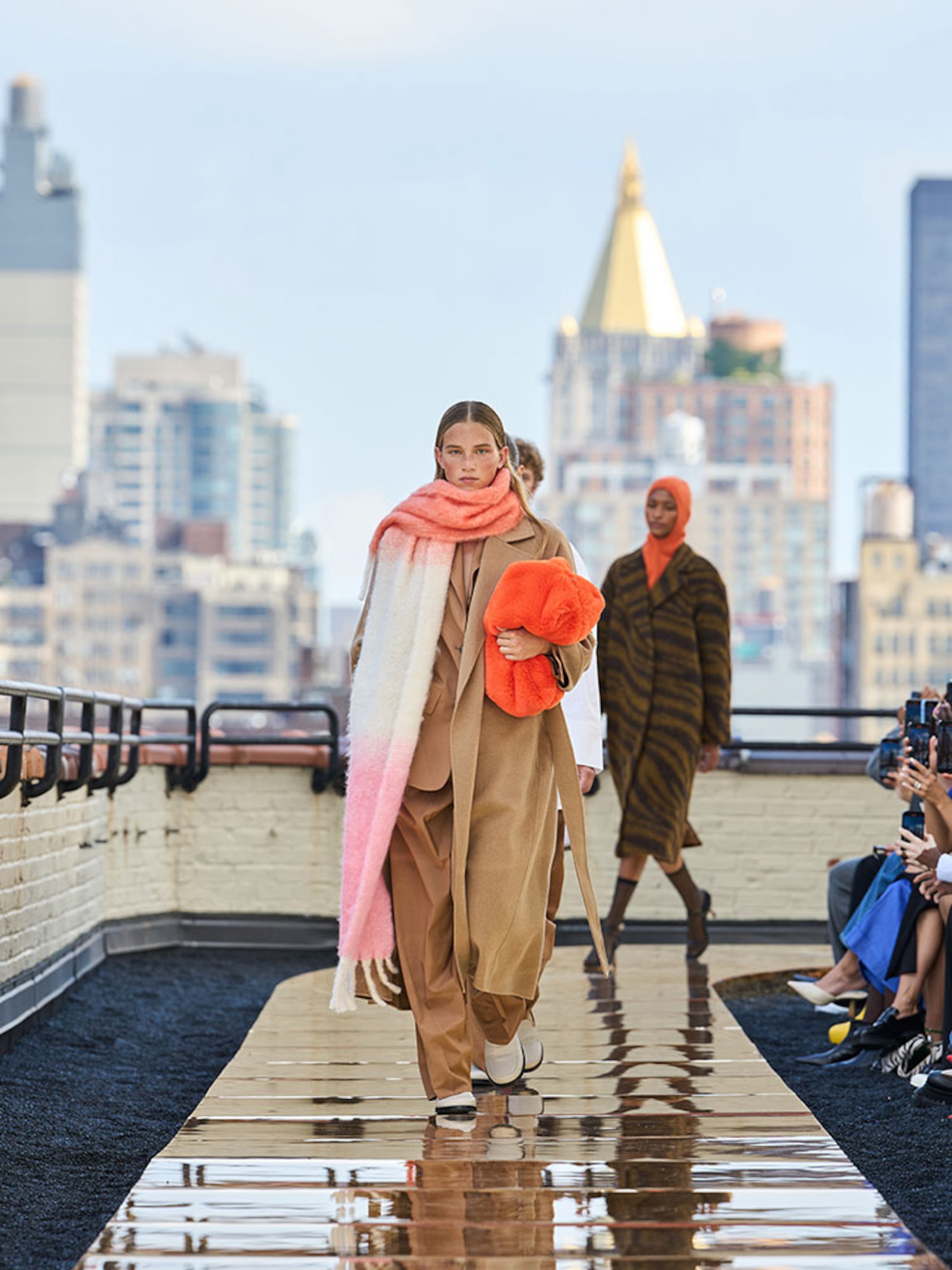 Person wearing oversized scarf, brown matching suit with beige maxi coat on