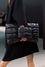 Placeholder for: Person holding large black leather quilted bag