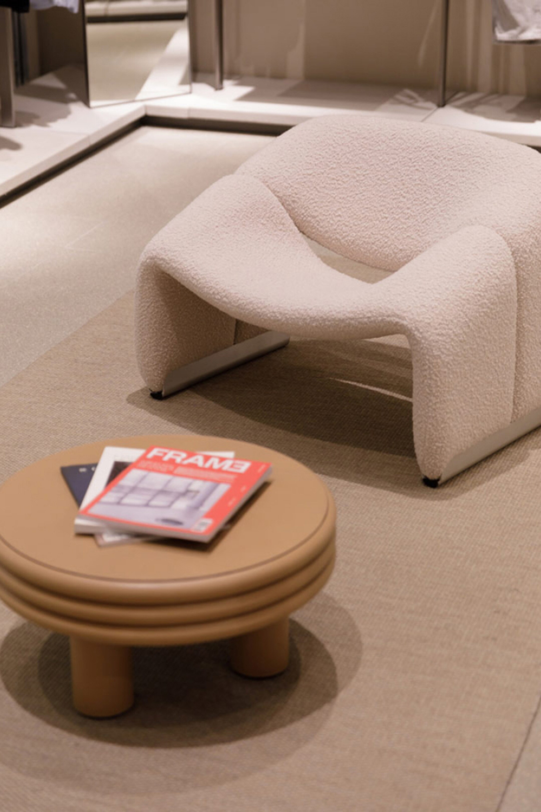 COS store showing recycled rug with a white chair and brown table