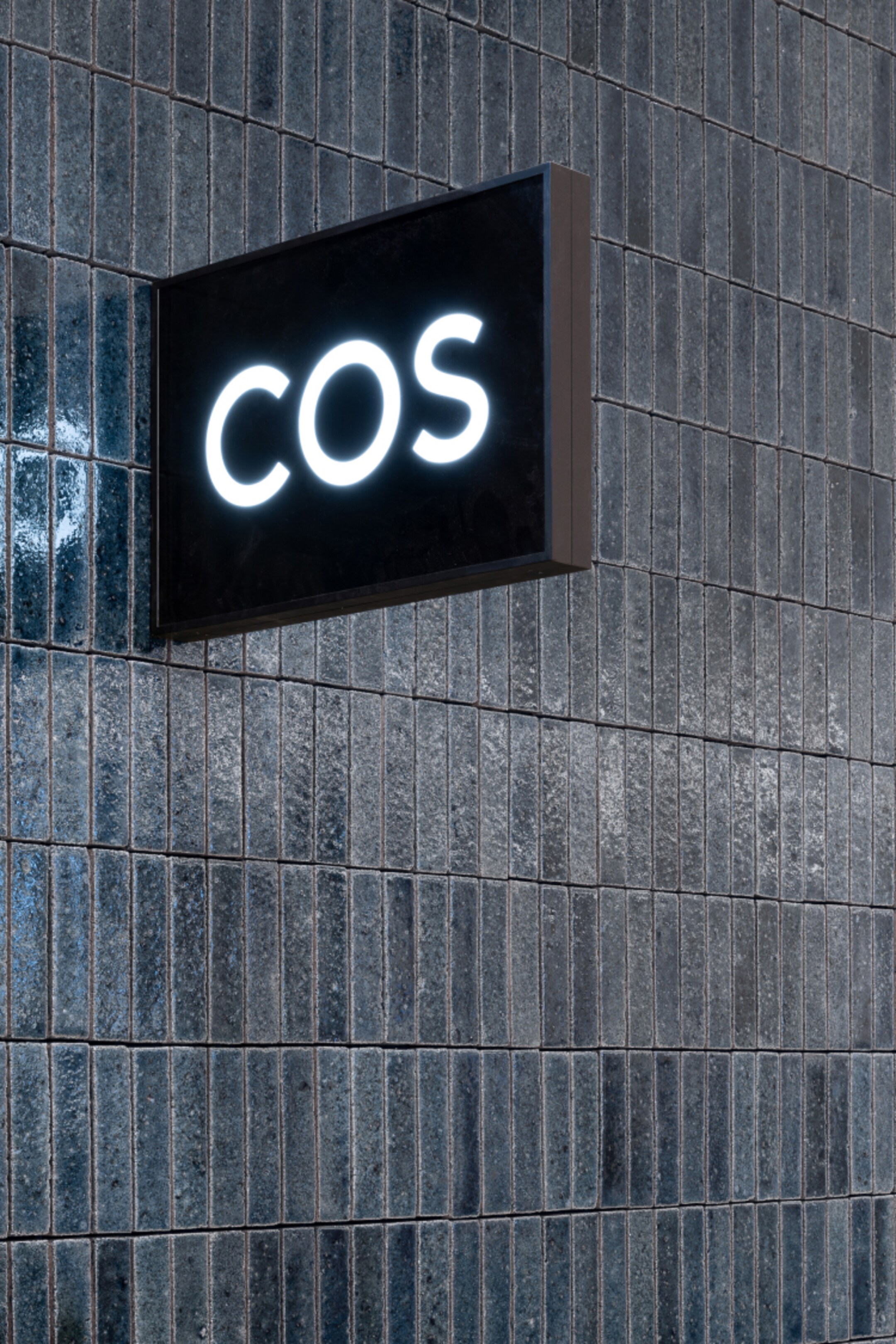 COS store logo on recycled ceramic tiled wall