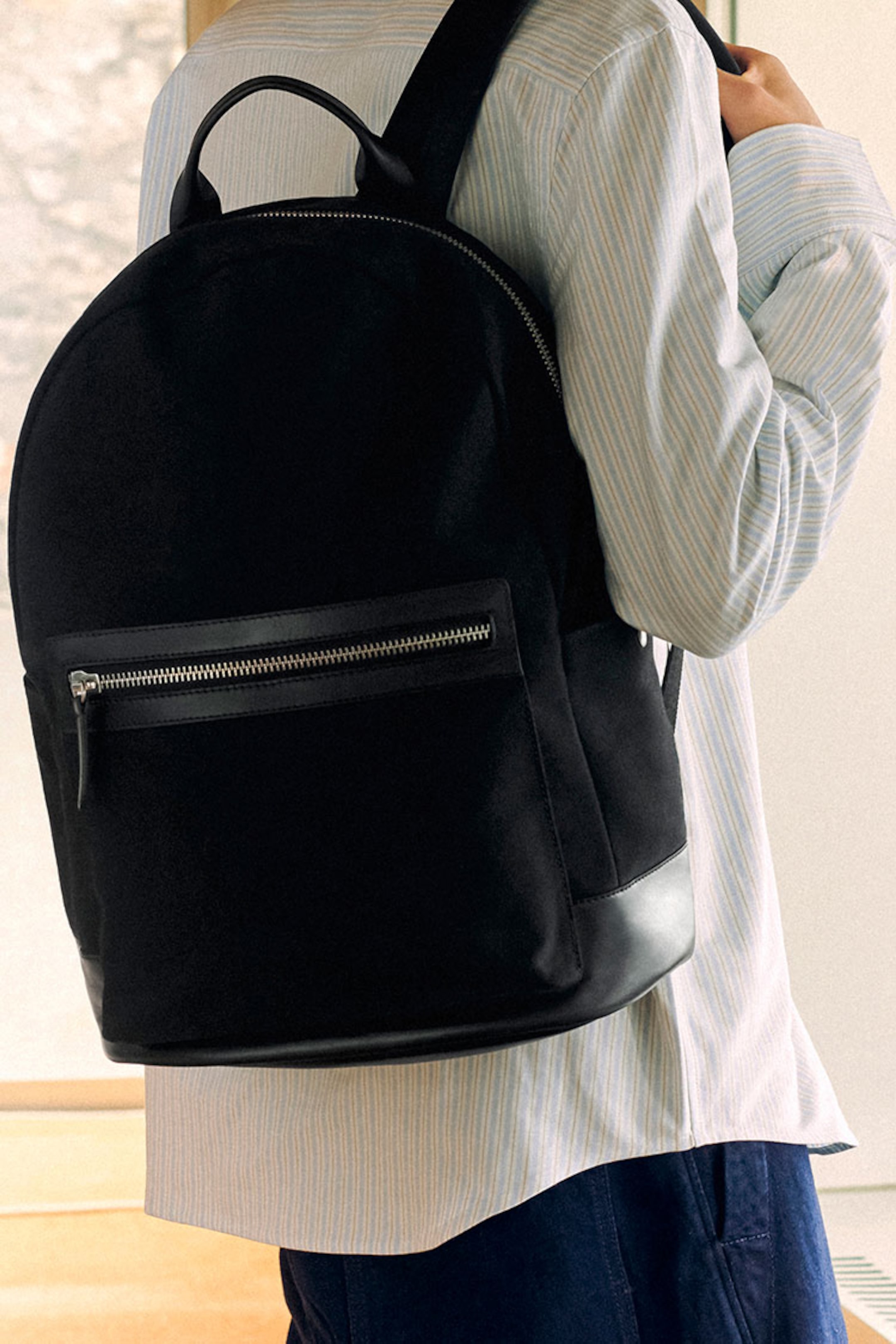 Person holding black rucksack