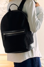 Placeholder for: Person holding black rucksack